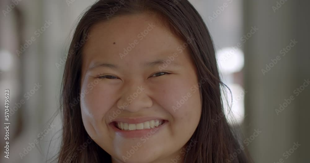Slow motion scene of a happy smiling and laughing Asian high school student girl. Slow motion scene of a happy smiling and laughing Asian high school student girl.