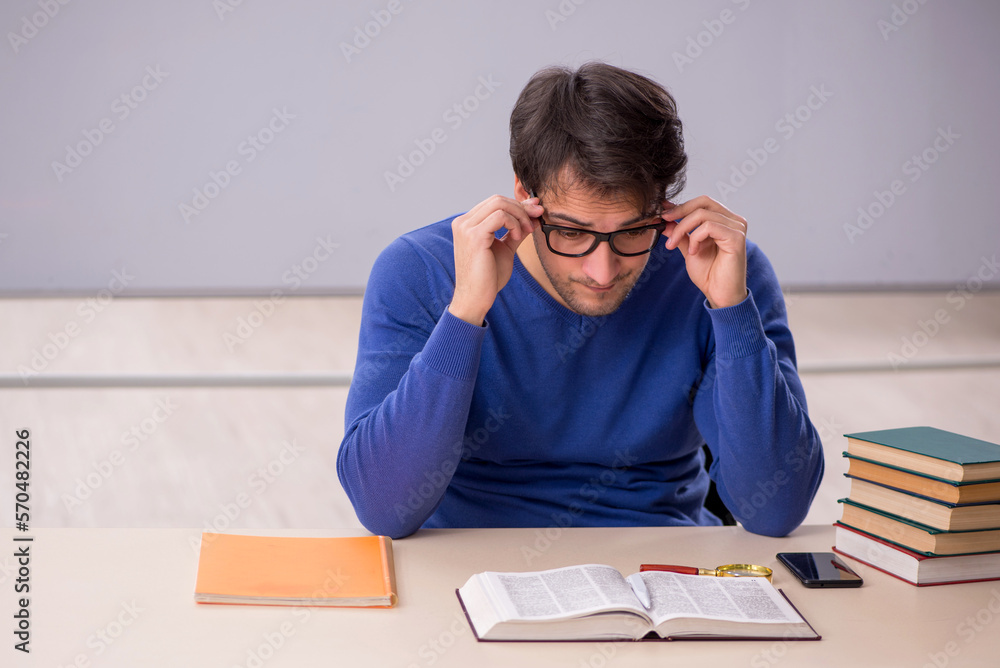 Young male student preparing for exams in the classroom Young male student preparing for exams in the classroom