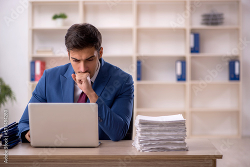 Young male employee and too much work in the office