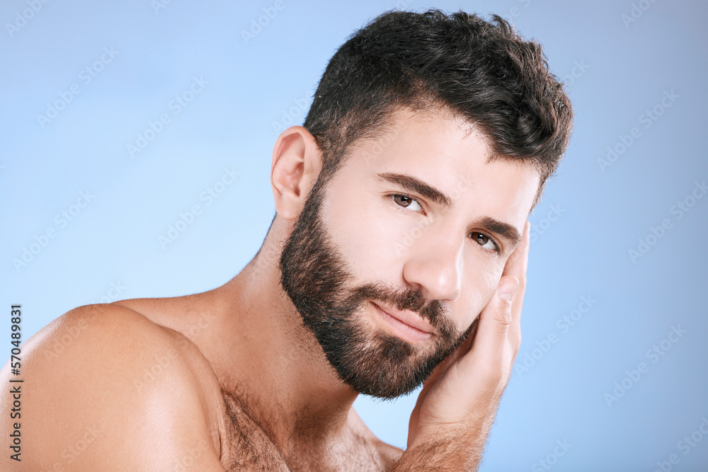 Fototapeta premium Skincare, glow and portrait of a man feeling face isolated on a blue background in a studio. Beauty, clean and model touching facial beard, grooming and cleaning for dermatology treatment on backdrop