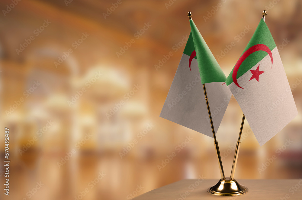 Small flags of the Algeria on an abstract blurry background