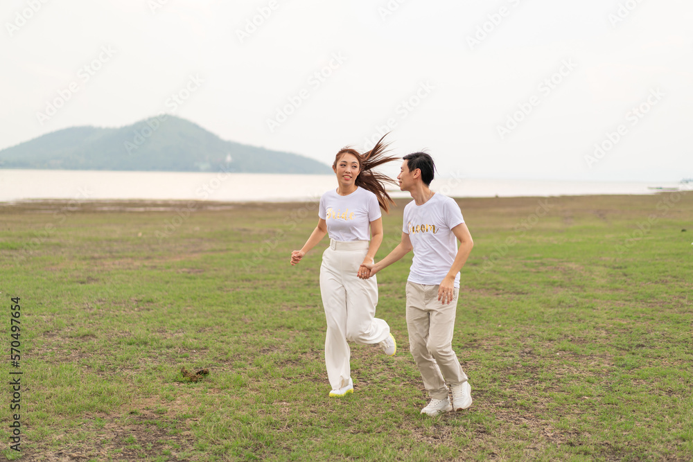Happy young Asian couple in bride and groom t-shirt Happy young Asian couple in bride and groom t-shirt