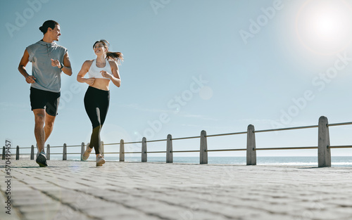 Couple, fitness and running by beach on mockup for exercise, workout or cardio routine together. Happy man and woman runner taking a walk or jog for healthy wellness or exercising in Cape Town photo