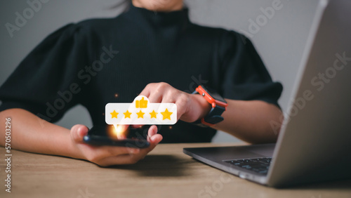 Hand pressing on smartphone screen with gold five star rating feedback icon and press level excellent rank for giving best score point to review the service , business concept