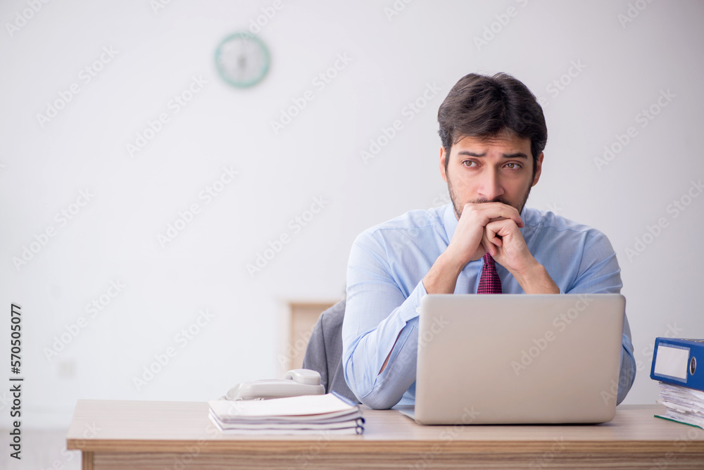 Young male employee sitting in the office Young male employee sitting in the office