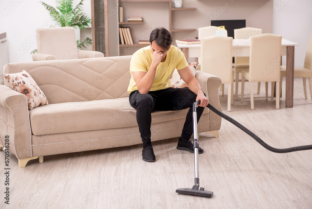 Young man doing housework indoors Young man doing housework indoors