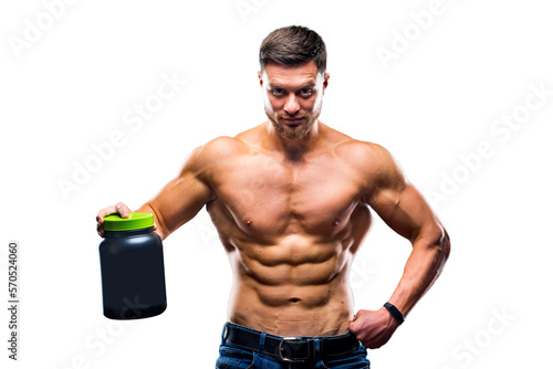 Fotografie Male athlete bodybuilder with a naked torso holds a jar of sports nutrition in his hands and poses on a blue background