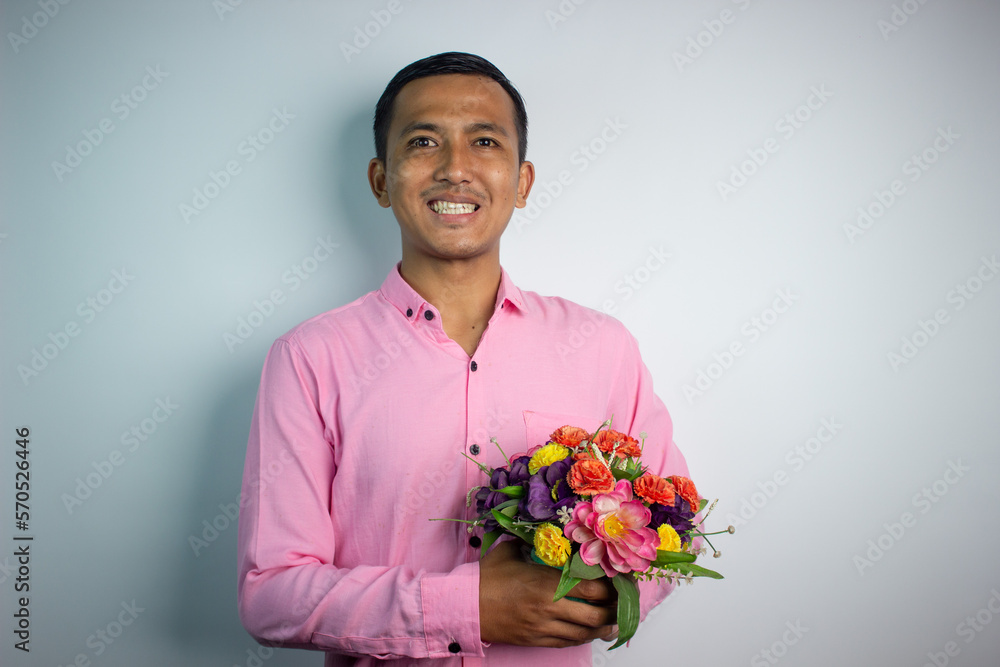 Portrait of Asian young man holding flower wearing pink shirt isolated on white background. Portrait of Asian young man holding flower wearing pink shirt isolated on white background.