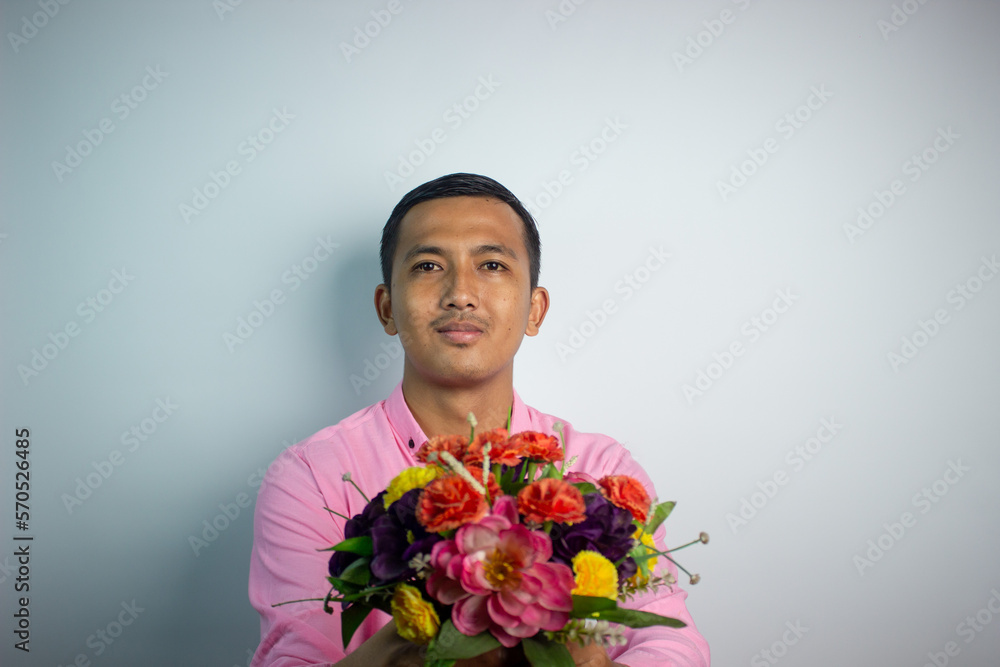 Portrait of Asian young man holding flower wearing pink shirt isolated on white background. Portrait of Asian young man holding flower wearing pink shirt isolated on white background.