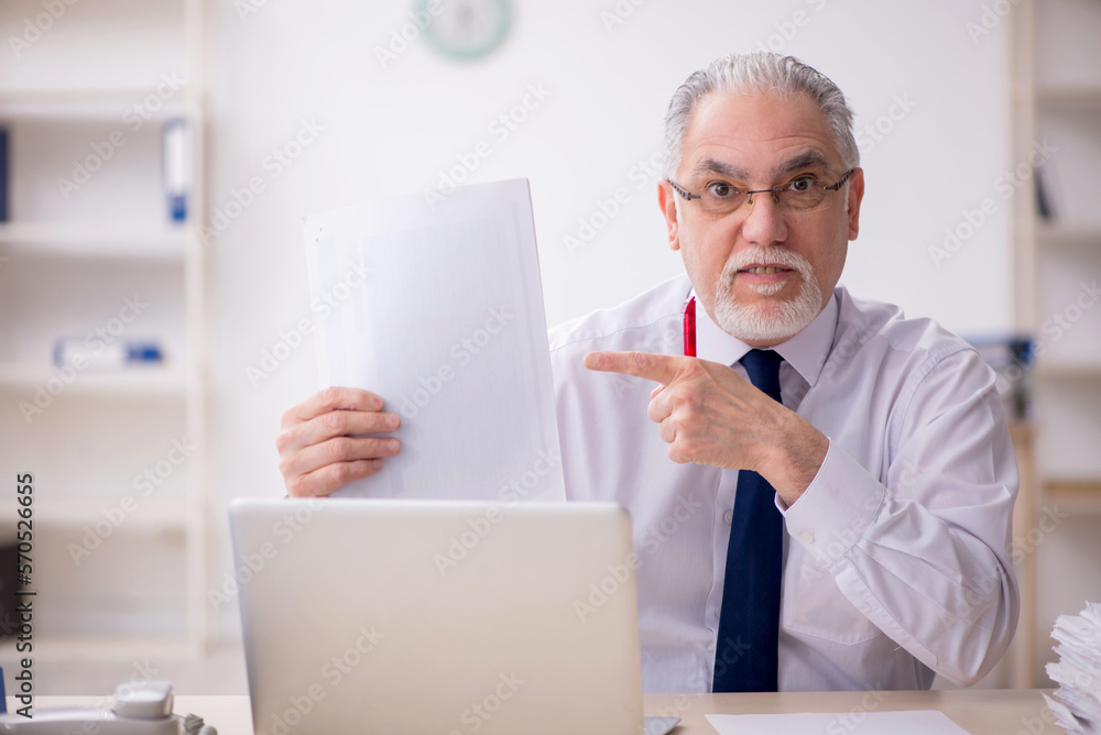 Old male employee working in the office Old male employee working in the office