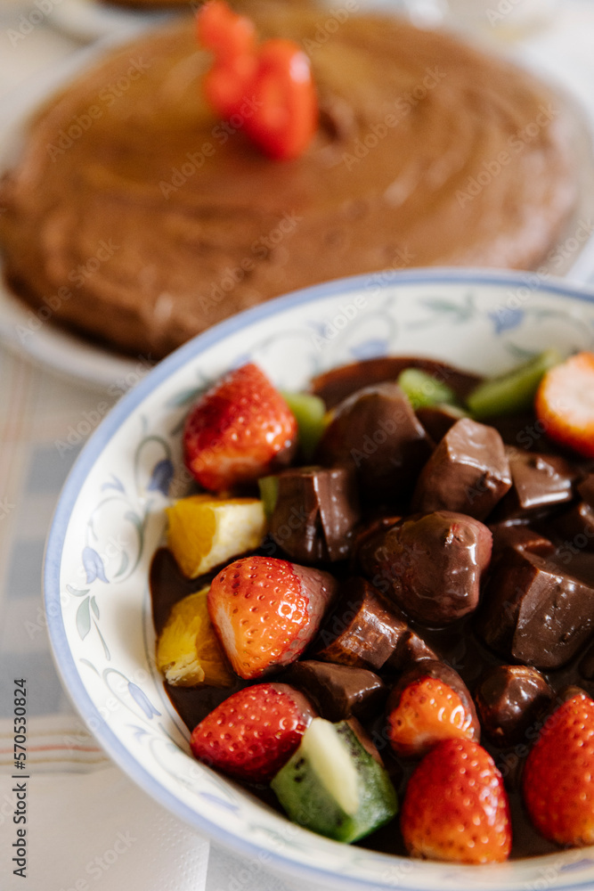 Fresh fruits and in bowl with chocolate on table with birthday cake Fresh fruits and in bowl with chocolate on table with birthday cake