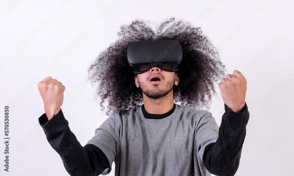 Enjoying a video game with virtual reality glasses. Young man with afro hair on white background