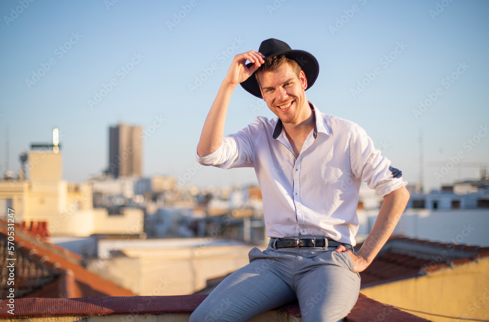 Smiling young boy with hat on the roof of a building Smiling young boy with hat on the roof of a building