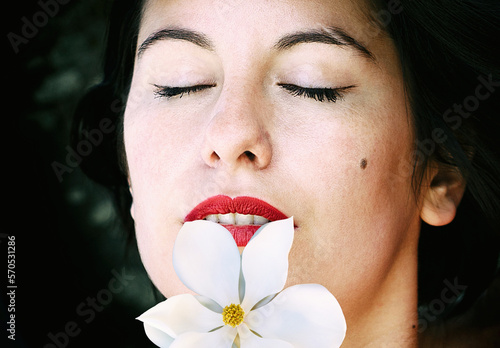 woman with closed eyes and a magnolia tree on her lips