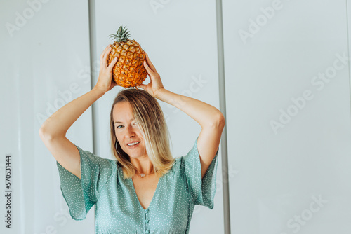 Woman holding Azorean pineapple on her head smiling at camera photo