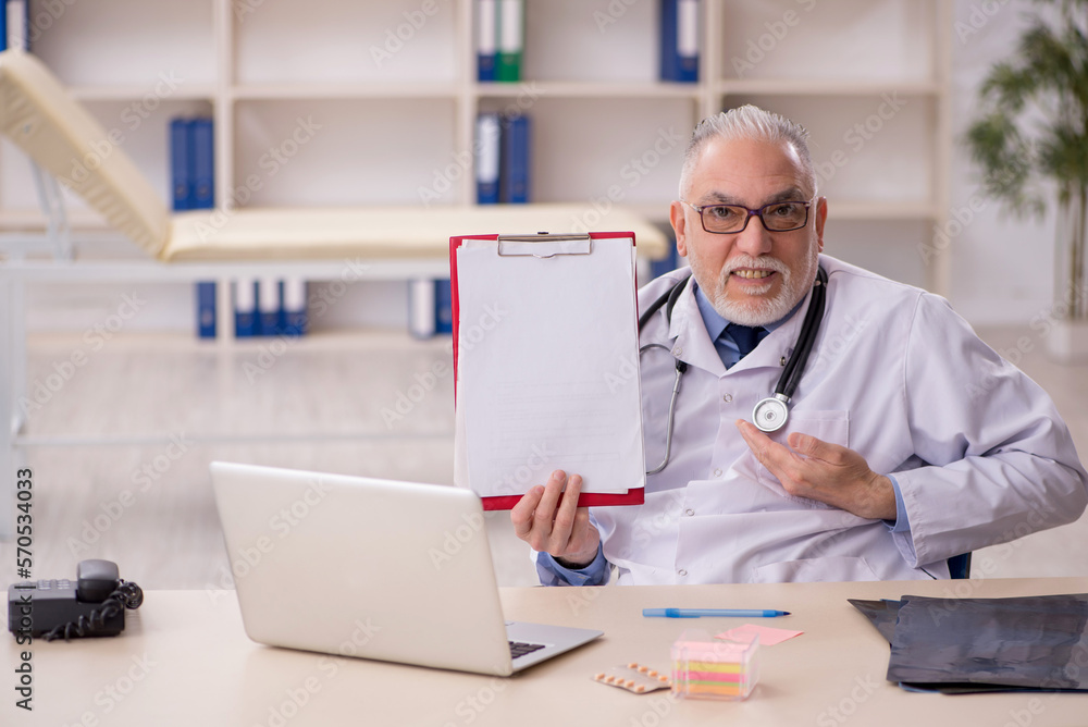 Old male doctor working in the clinic Old male doctor working in the clinic