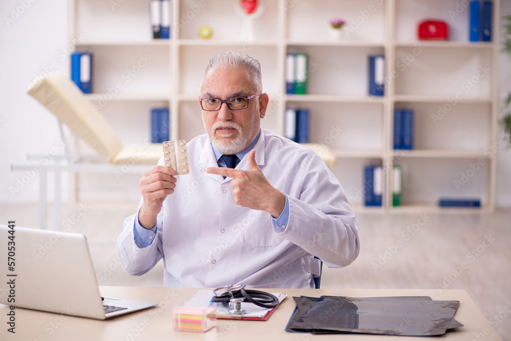 Old male doctor working in the clinic Old male doctor working in the clinic
