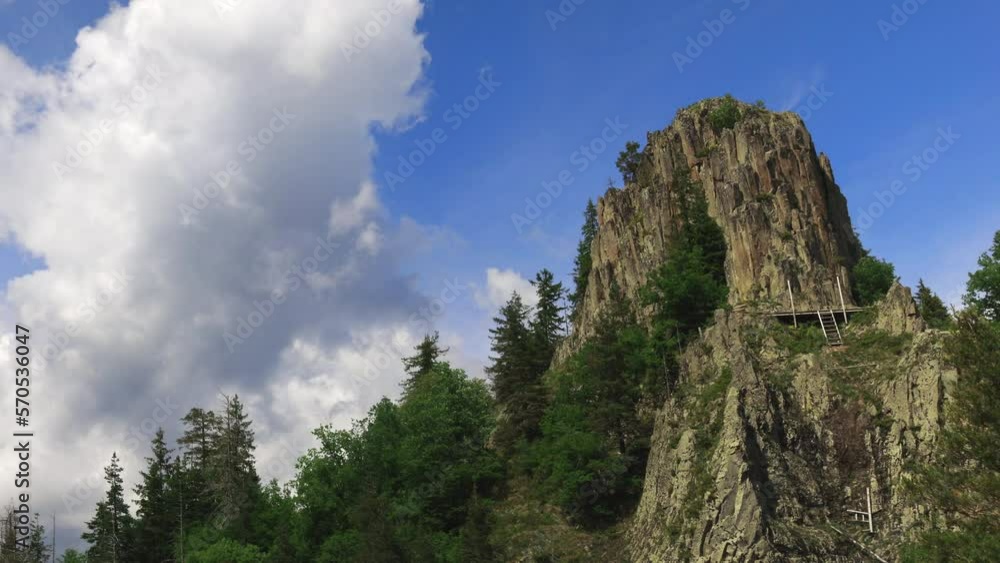 Rocky peak of one of the Rhodope Mountains with a slope with a spruce forest against the background of a cloudy sky Rocky peak of one of the Rhodope Mountains with a slope with a spruce forest against the background of a cloudy sky