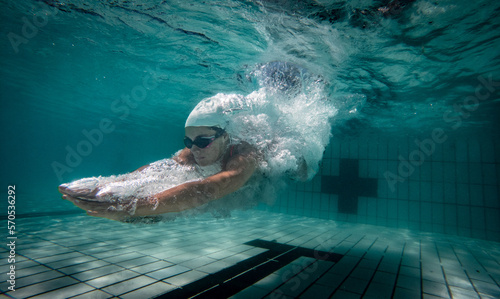Underwater photo of a female swimmer diving into an olympic standard swimming pool