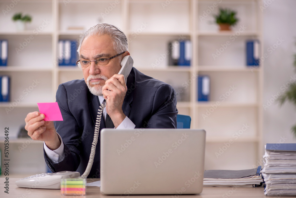 Old male employee working in the office Old male employee working in the office