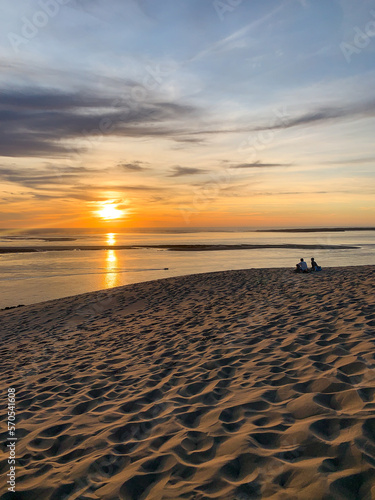Couple at sunset on sand dune sea view in dune du pilat