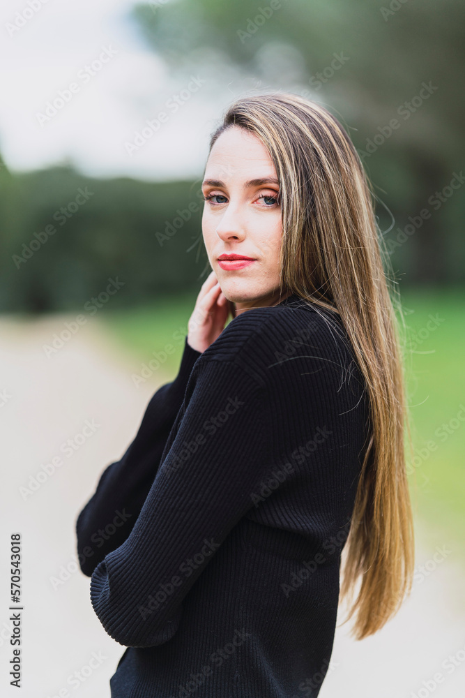 Chica joven con pelo largo liso y vestidos pintorescos en zona boscosa tomándose fotos y posando
