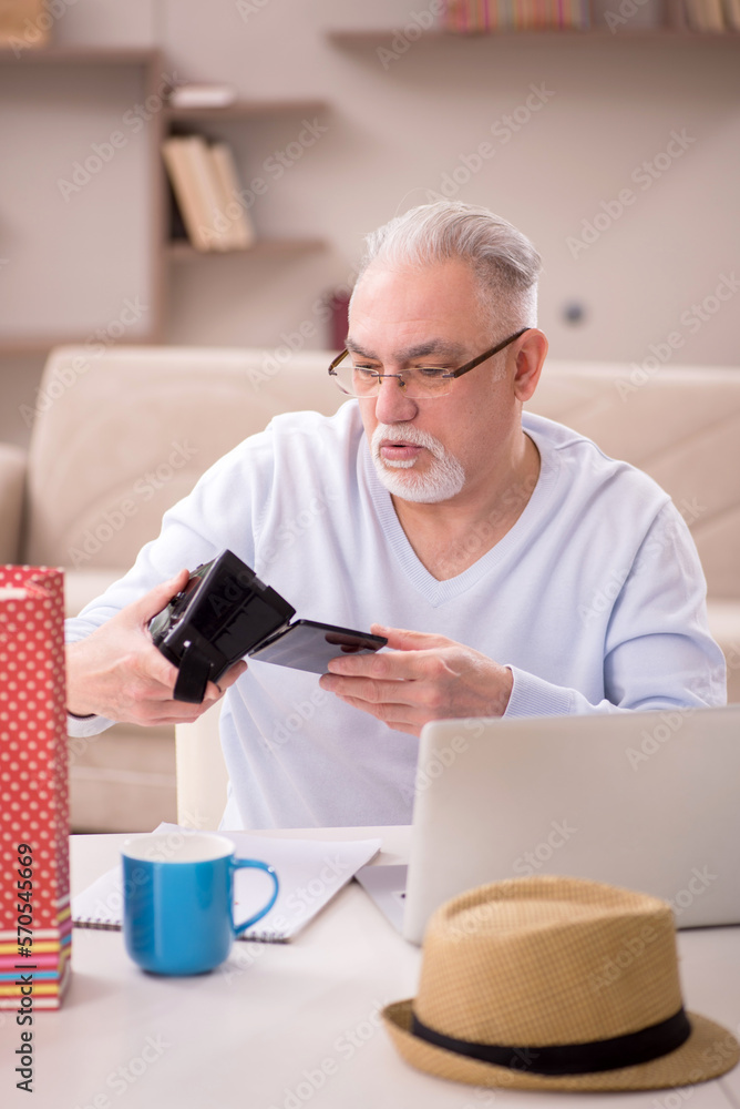 Old man with many bags in Christmas concept at home Old man with many bags in Christmas concept at home