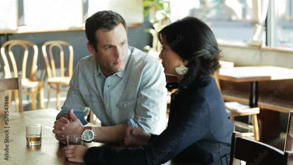 Couple chatting at a table enjoying a drink Couple chatting at a table enjoying a drink