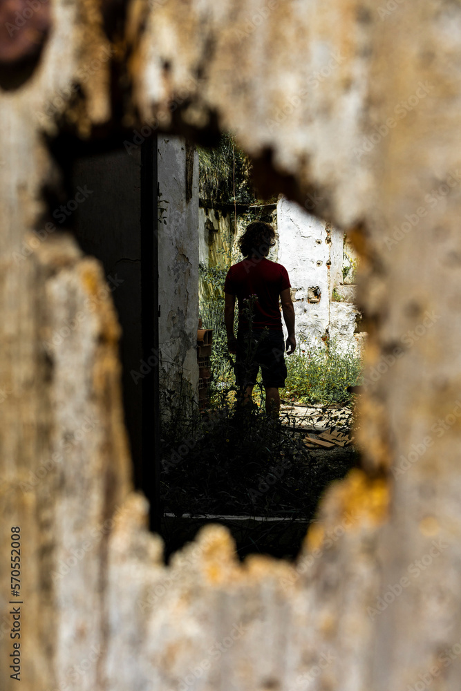 young boy with his back turned shot through a wooden door hole young boy with his back turned shot through a wooden door hole