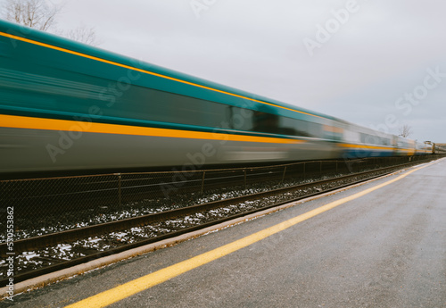 Blurred fast moving passenger train travelling down the tracks.