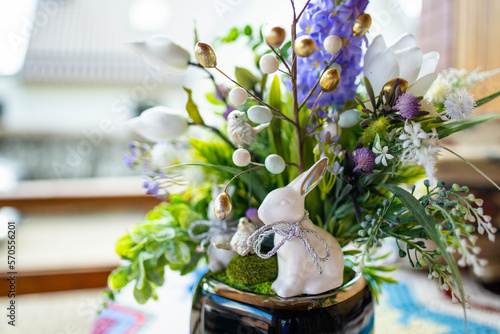 Schilderij op canvas Easter table decoration made ot artificial flowers, green leaves, birds, and small eggs