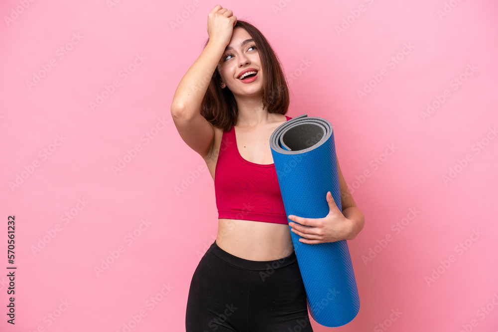 Young sport Ukrainian woman going to yoga classes while holding a mat isolated on pink background has realized something and intending the solution Young sport Ukrainian woman going to yoga classes while holding a mat isolated on pink background has realized something and intending the solution