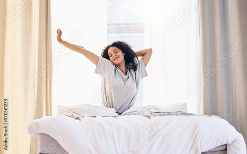 Morning stretching, black woman and wake up in home bedroom after sleeping or resting. Relax, peace and comfort of happy female stretch after sleep feeling fresh, awake and well rested in house. photo