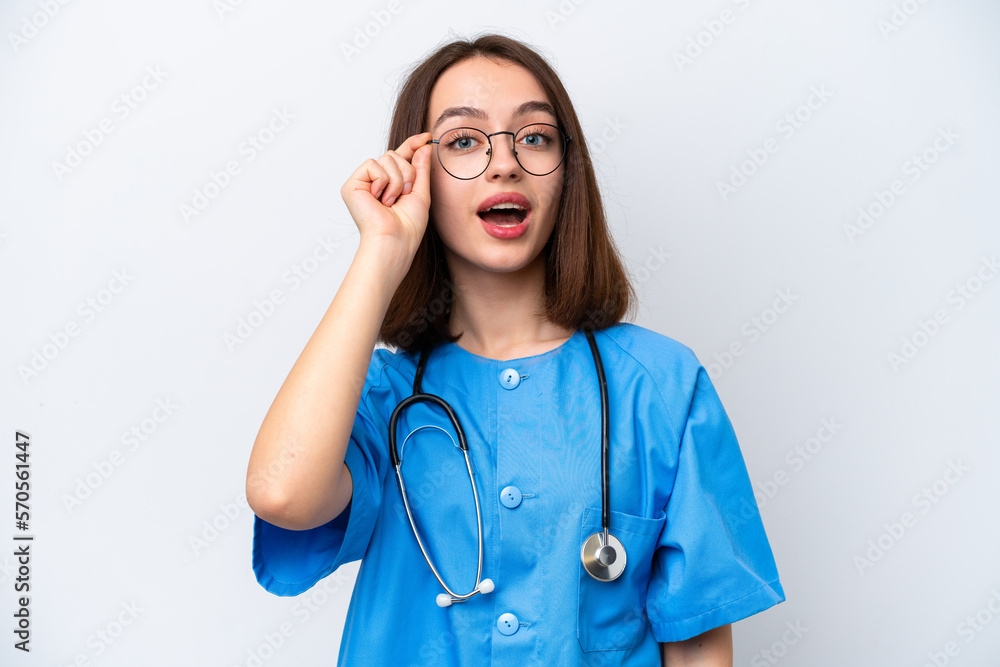 Young nurse Ukrainian woman isolated on white background with glasses and surprised Young nurse Ukrainian woman isolated on white background with glasses and surprised