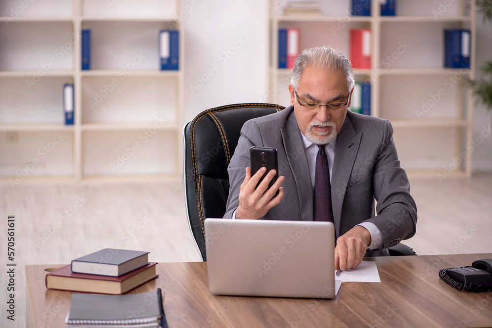 Old male employee working in the office Old male employee working in the office