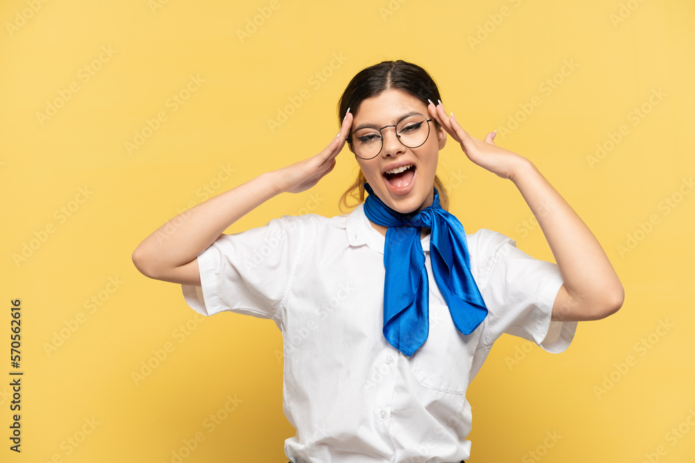 Airplane stewardess isolated on yellow background with surprise expression Airplane stewardess isolated on yellow background with surprise expression