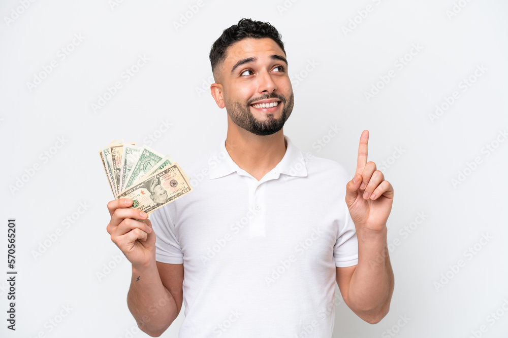 Young Arab man taking a lot of money isolated on white background pointing up a great idea Young Arab man taking a lot of money isolated on white background pointing up a great idea
