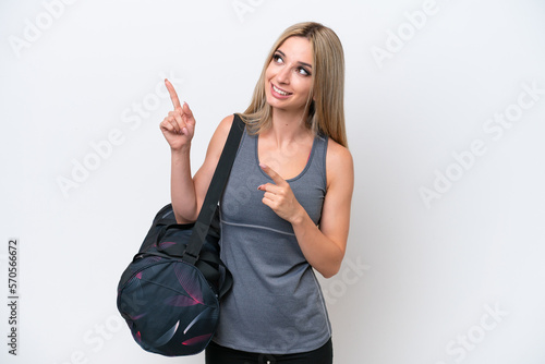 Young sport woman with sport bag isolated on white background pointing with the index finger a great idea
