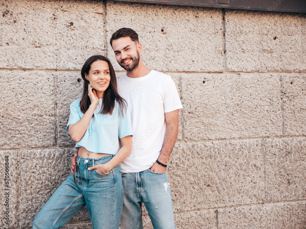 Smiling beautiful woman and her handsome boyfriend. Woman in casual summer jeans clothes. Happy cheerful family. Female having fun. Sexy couple posing in the street near wall Smiling beautiful woman and her handsome boyfriend. Woman in casual summer jeans clothes. Happy cheerful family. Female having fun. Sexy couple posing in the street near wall