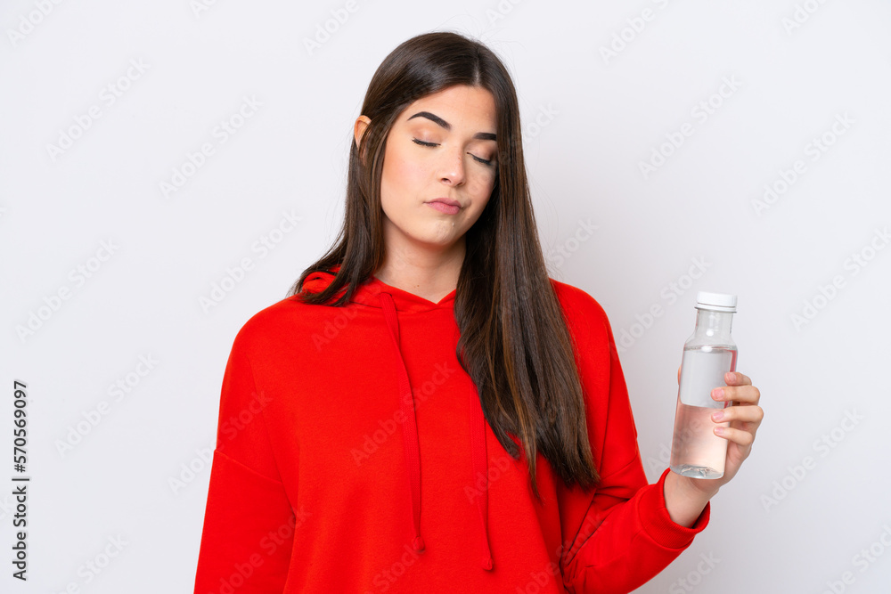 Young Brazilian woman with a bottle of water isolated on white background with sad expression Young Brazilian woman with a bottle of water isolated on white background with sad expression