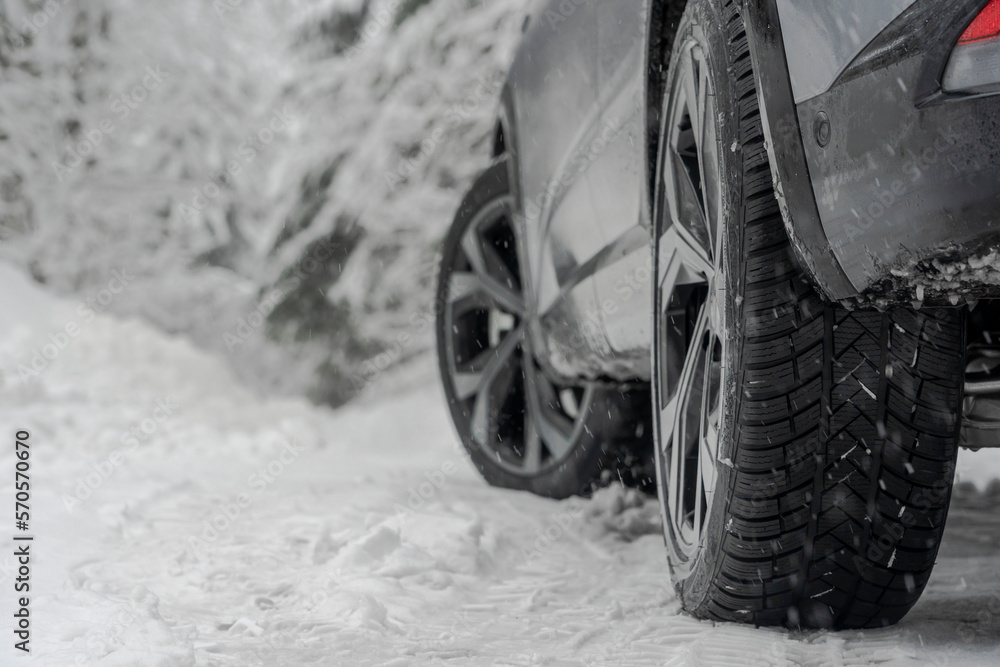 Close up shot of a car winter tire on s snow