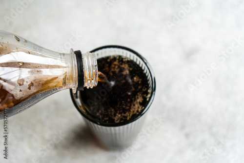 Overhead view of glass of cola being poured photo