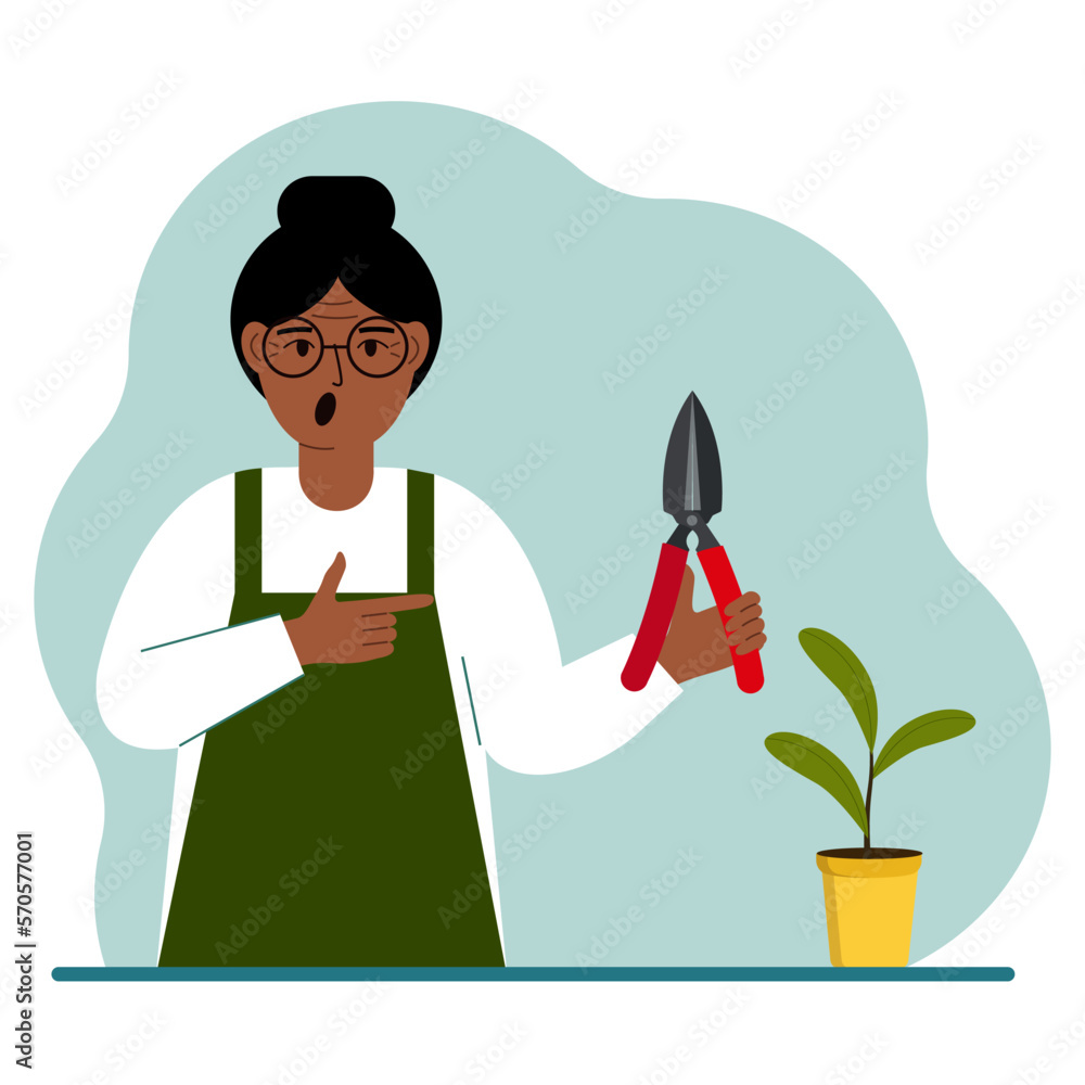 Fototapeta premium A gardener is a woman in working clothes, he has a pruner in his hand.