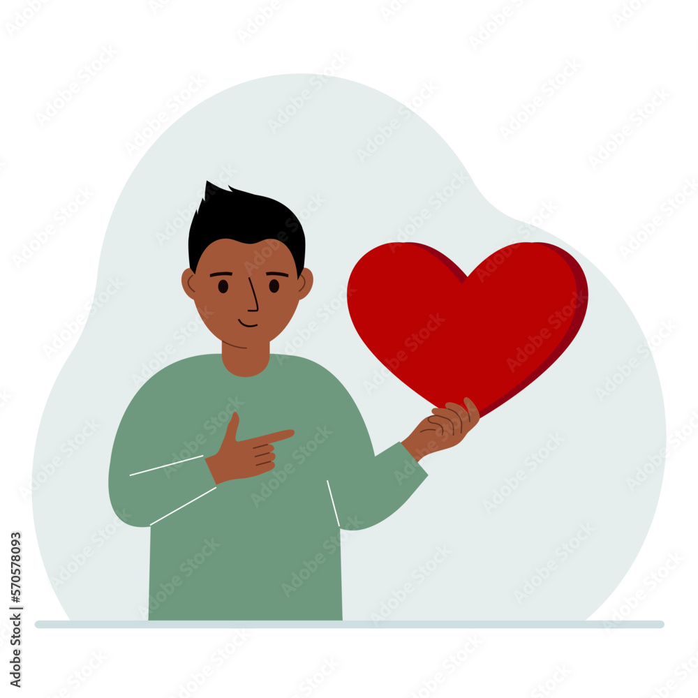 A boy holds a big red heart in his hand. The concept of volunteering, romantic relationship or love.
