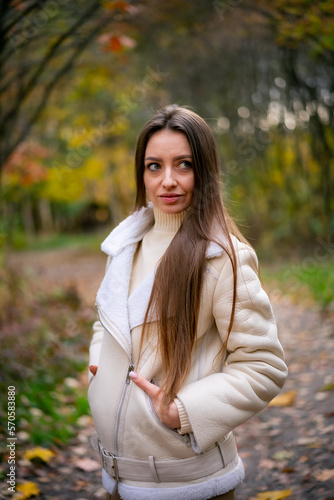Autumn portrait of young pretty woman. Lifestyle model walking in autumn park.