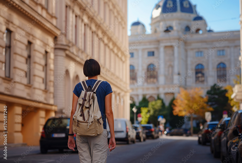 Fototapeta premium summer female solo trip to Europe, happy young woman walking on european street of Vienna, Austria