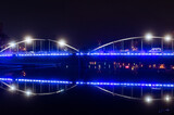 podświetlony na niebiesko most nad rzeką Odrą w Opolu w nocy