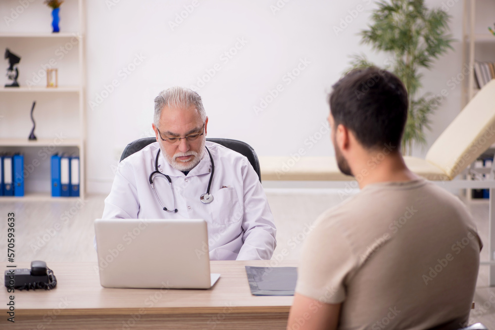 Young male patient visiting old male doctor Young male patient visiting old male doctor