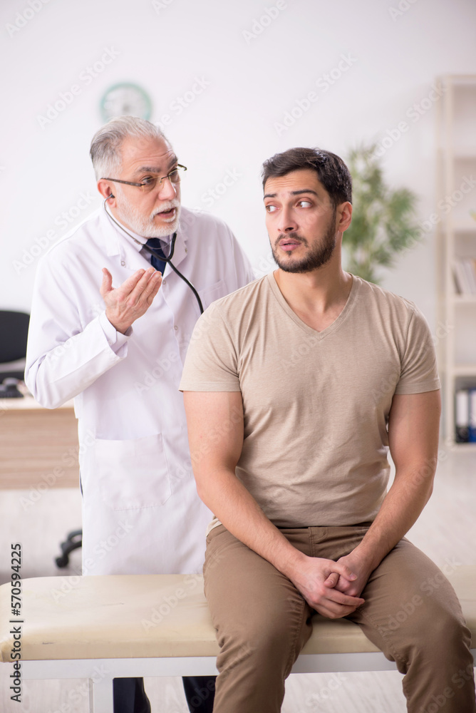Young male patient visiting old male doctor Young male patient visiting old male doctor