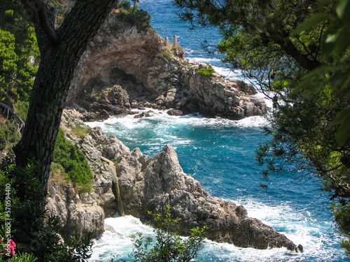 Turquoise water splashing against a rocky shore near Dubrovnik, Croatia.  Image has copy space.